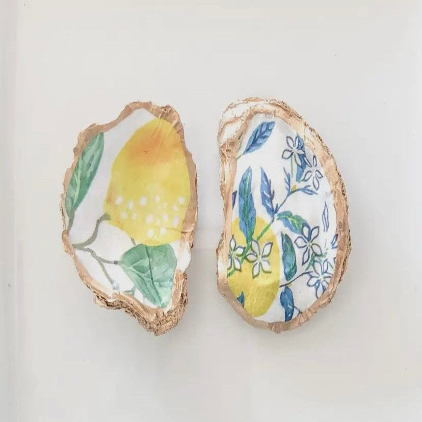 Unique oyster shell jewelry dish with hand-painted lemons and gold trim, offering a touch of coastal elegance to any dresser or vanity