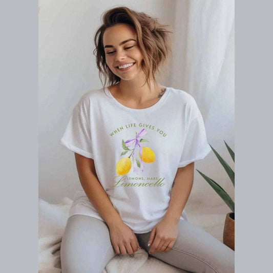 White graphic tee with the words "When Life Gives You Lemons, Make Limoncello" printed in a bold script and lemons, celebrating Italian summer style 