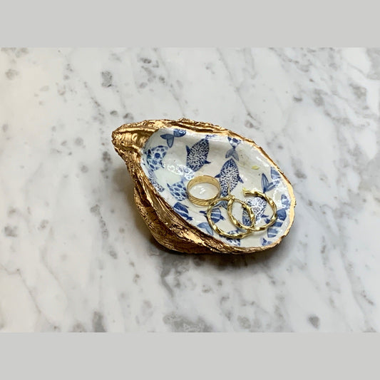Hand-painted ceramic fish-shaped jewelry dish featuring abstract blue coastal designs, and gold trim evoking the charm of the Amalfi Coast